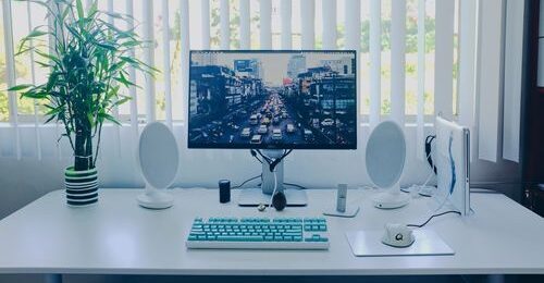 stylish work desk with a laptop, keyboard, and monitor